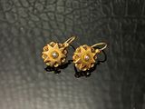 paire de boucles d'oreilles en or et diamants sur fond noir