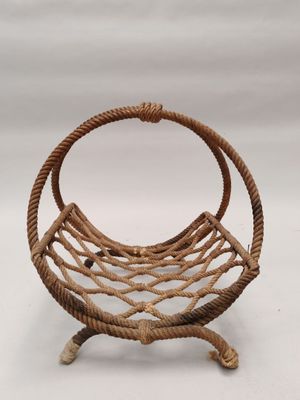 un gros plan d'un panier en osier posé sur un support, sur fond blanc