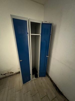 a blue door in a white room with a wooden floor