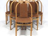 six chaises en bois aux assises rembourrées marron sont disposées en cercle