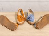 three pairs of women ' s shoes sitting on top of a wooden table