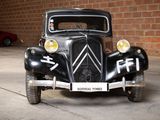 a black car parked in a garage with a brick wall behind it