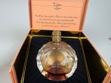 a glass perfume bottle in a box on a table