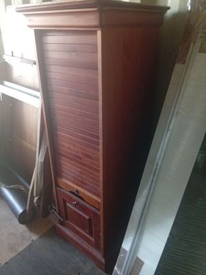 un grand meuble en bois dans le coin d'une pièce