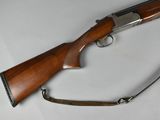the rifle is laying on a white surface with a sling