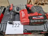 une perceuse sans fil rouge et deux autres outils posés sur une table