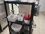 a black cart with dishes on top of it in a kitchen