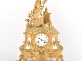 une horloge en or surmontée d'une statue