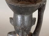 statue of a man with a bowl on his head on a table
