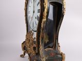 a black and gold clock sitting on a white surface