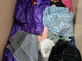 a cardboard box filled with clothes and a backpack