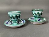 two cups and saucers that are sitting on a table