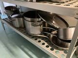 de nombreuses casseroles et poêles sur l'étagère de la cuisine