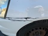 une voiture blanche qui a été gravement endommagée par une borne d'incendie