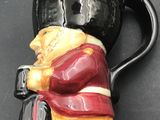 a coffee cup shaped like a person sitting on a chair