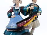 une figurine représentant un homme et une femme tenant un cerf-volant