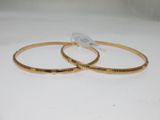 deux bracelets rigides de couleur dorée, sur lesquels sont gravés des mots