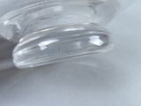 a close up of a clear glass object on a white surface