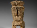 une sculpture en bois représentant un homme coiffé d'un chapeau
