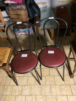 Plusieurs chaises sont alignées en rangée sur le sol.