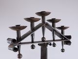 a metal candle holder that has five candles on it
