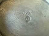 a silver pot with a flower on it