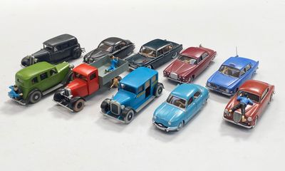 several toy cars are lined up in a row on a white surface