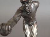 a silver statue of a baseball player holding a ball