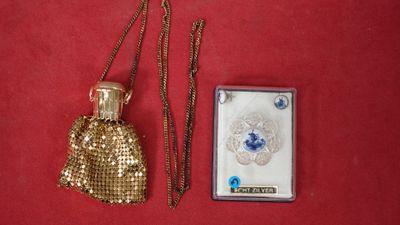 un porte-monnaie doré et un porte-cartes posés sur un fond rouge