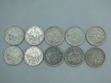 six types différents de pièces d'argent sur une surface blanche