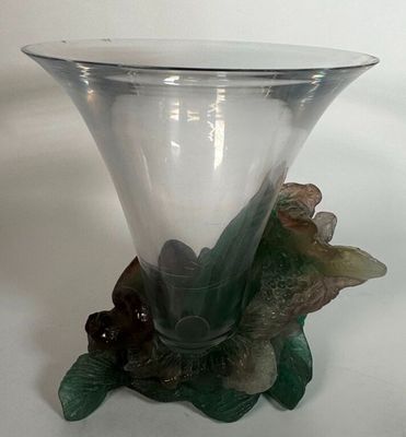 a glass vase with a flower on it on a table