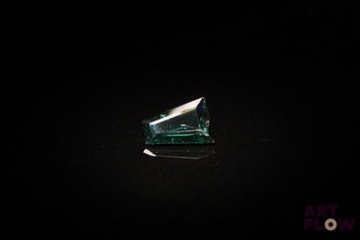 gros plan d'un diamant vert sur une surface noire