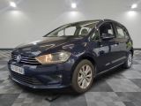 une Volkswagen Golf bleue garée sur un sol à damier dans un garage