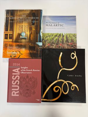 trois livres posés sur une table recouverte d'une nappe blanche