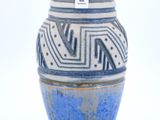 un vase bleu et blanc posé sur une surface blanche