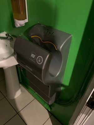 un mur végétal dans une salle de bains équipée de toilettes et d'un lavabo