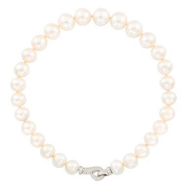 un bracelet en perles blanches avec un fermoir en diamant