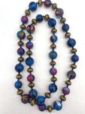 un collier de perles bleues et violettes sur un fond blanc