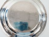 a silver plate on a white surface with a blue background