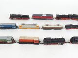 several toy trains are lined up in a row on a white surface