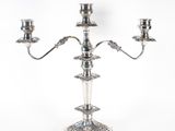 a silver plated candelab with three candles on a stand