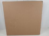 an open cardboard box sitting on a white surface next to a white wall