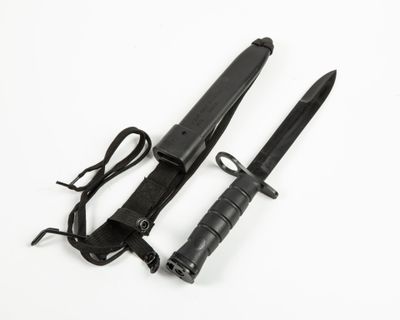 une paire de couteaux noirs sur fond blanc, avec un cordon