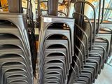 de nombreuses chaises empilées les unes sur les autres dans une pièce