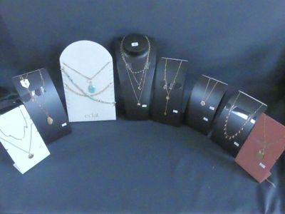 de nombreux colliers et bracelets exposés sur un tissu bleu
