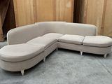 un canapé et un pouf dans une pièce aux murs en bois