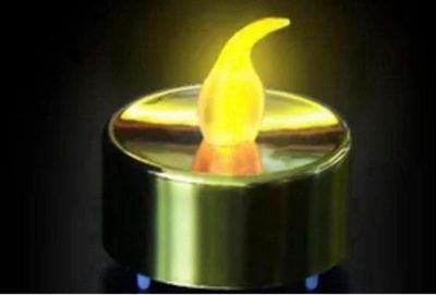 une bougie jaune allumée dans l'obscurité