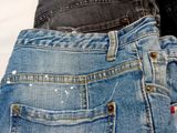 three pairs of jeans stacked on top of each other