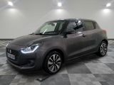 a grey suzuki swift is parked on a checkered floor