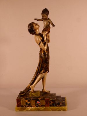 statue en bronze d'une femme tenant un enfant sur un socle en marbre